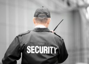 Male security guard using portable radio outdoors